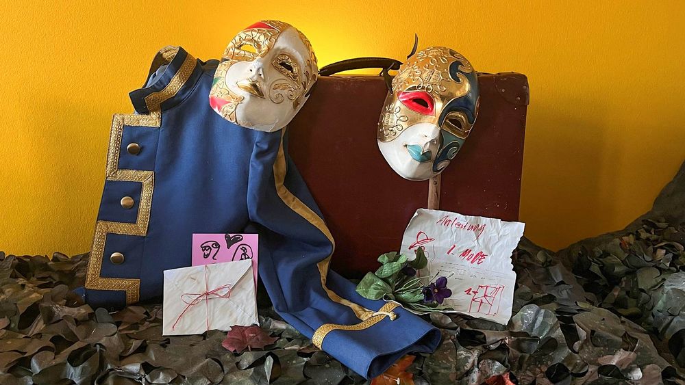 Gestellte Szene mit einem Koffer, Masken, einer Uniformjacke und Papier Quelle: Larissa Milane Schulze