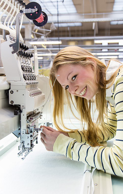 Foto: von Gerischer / WHZ. Ein Studierende nimmt Einstellungen an einer Textilmaschine vor.