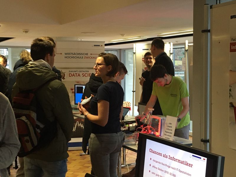 Foto: Interessenten an einem Informationsstand zum Hochschulinformationstag.