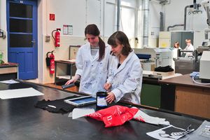 Foto: Zwei Studierende tätigen einen Siebdruck. Textiles "Begreifen" im Technikum des ITL. Bildquelle: Susanne Baumung