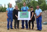 Foto: Gruppenbild mit 5 Personen. Diese halten ein Plakat mit der Aufschrift "Hier entsteht ein neues Wohnheim".