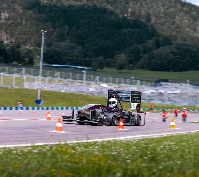 Rennwagen auf einer Rennstrecke umgeben von Wiese
