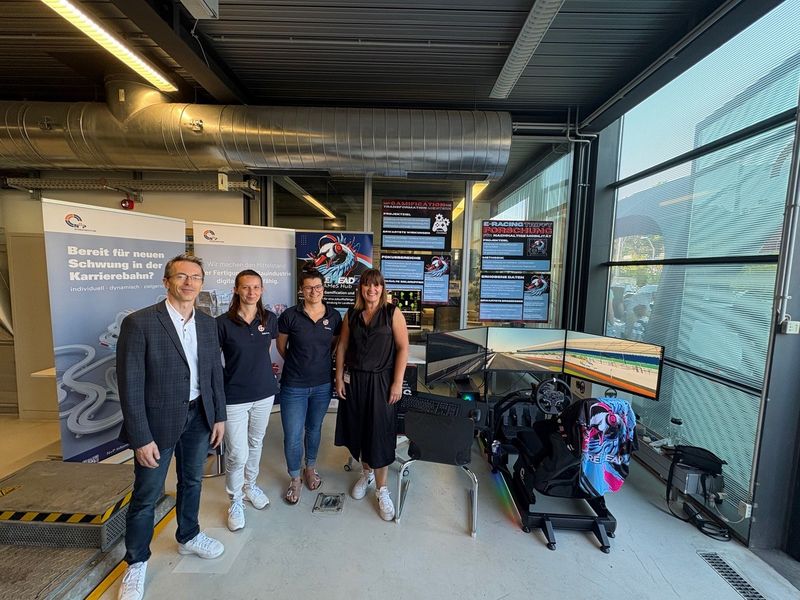 Gruppenfoto vor einem Rennsimulator