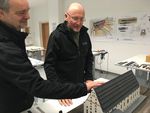 Foto: 2 Mitarbeiter am Tastmodell des Kornhauses für Sehbehinderte.