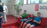 Foto: In der Kletter- und Boulderhalle Zwickau sitzen 3 Schüler auf einem Sofa und lächeln in die Kamera.