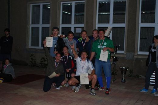 Foto: Gruppenbild einer Sportgruppe mit Medaillen um den Hals und Urkunden in den Händen.