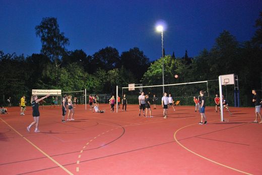 Foto: Blick auf den Sportplatz mit aktiven Spielern auf zwei Volleyballfeldern.