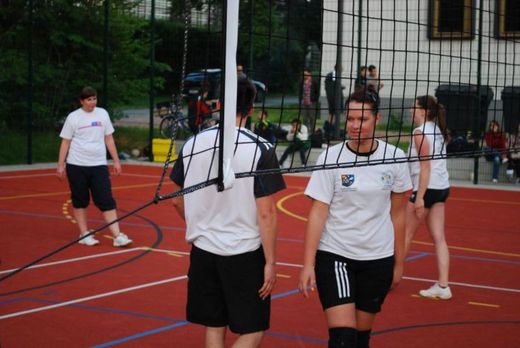 Foto: Volleyball Spieler und Spielerinnen auf dem Spielfeld des Sportplatzes.