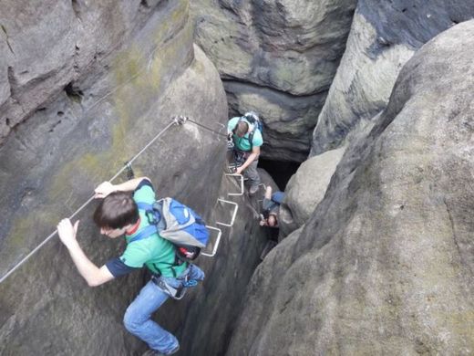 Foto: Outdoor mit Klettern. 3 Teilnehmer klettern an einem Felsen entlang.
