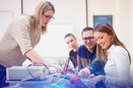 Junge Lehrerin unterrichtet Schüler in einem Technik-Kabinett in der Schule.