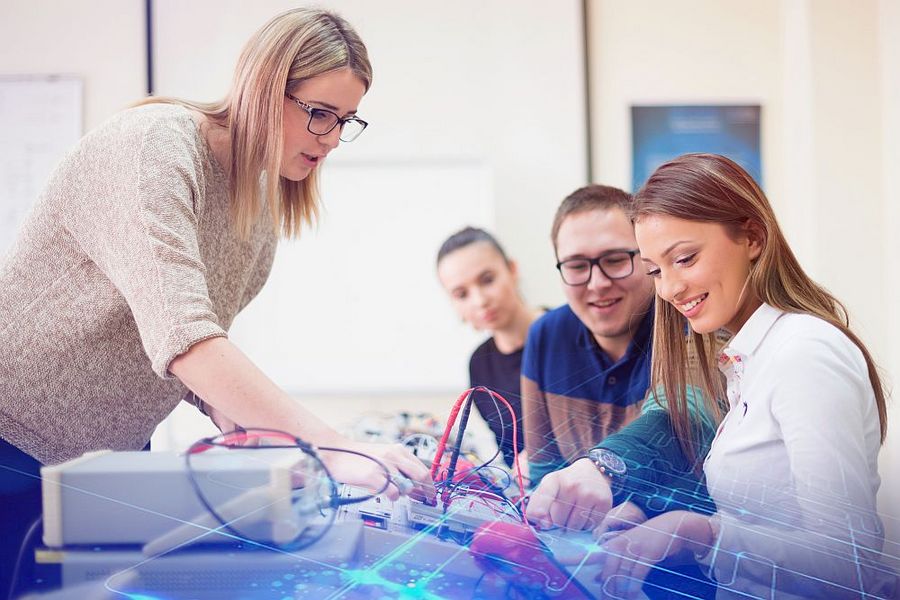 Junge Lehrerin unterrichtet Schüler in einem Technik-Kabinett in der Schule. 