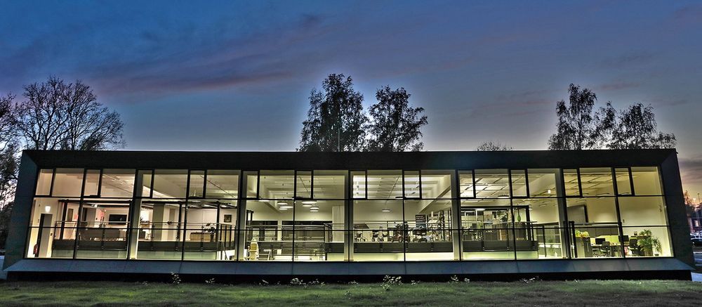 Foto: Ein modernes Gebäude, voll erleuchtet, in der Dämmerung fotografiert.