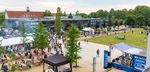 Blick über den Campus Scheffelstraße, ein schöner Sommerabend, im Vordergrund Bühne und Grillstand, im Hintergrund Laborgebäude, viele Familien spazieren über den Campus.
