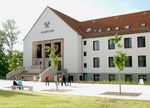 Foto: Gebäudeansicht. Eingangsbereich zur Aula Scheffelberg mit Personen.