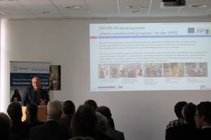 Foto: Referent Prof. Dr.-Ing. Torsten Merkel steht am Rednerpult und eröffnet vor den sitzenden Teilnehmern das 7. Symposium Produktionstechnik.