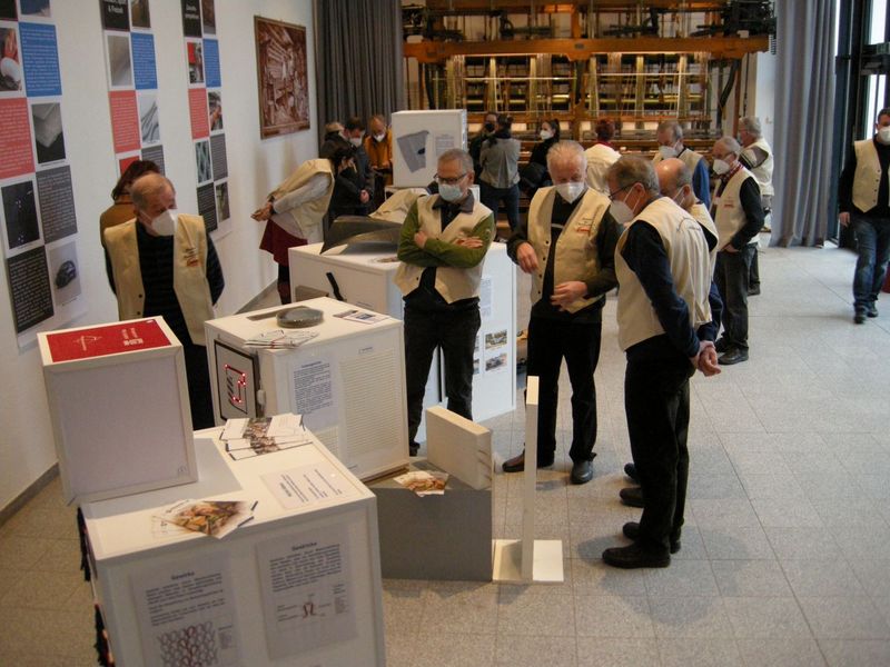 Foto: Mehrere Personen stehen zwischen Exponatenund Informationen einer Ausstellung.