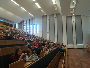 Foto: Teilnehmer der Kinderuni sitzen im Hörsaal. Die Besucher waren mit voller Konzentration dabei, einen Zwirn in zwei Garne zu zerlegen.