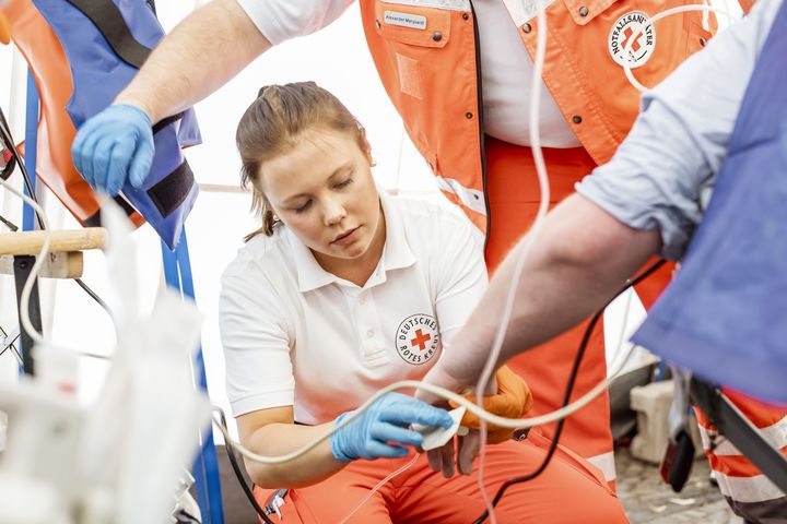 Rettungsdienst im Einsatz, Frau behandelt, weitere Personen unvollständig im Bild