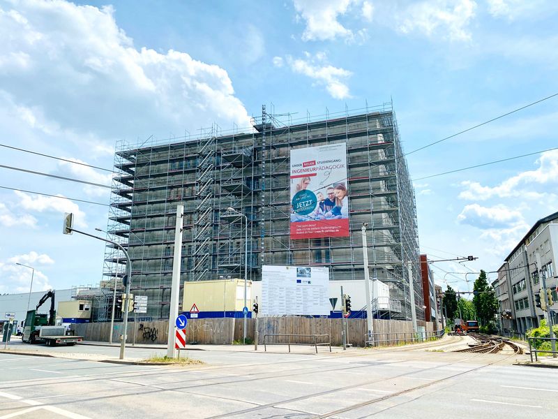 Das noch eingerüstete Gebäude des neuen Technikums der WHZ, das gebäude ist fast quadratisch und überragt die umstehenden Gebäude deutlich. 