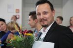 Foto: Ein Absolvent lächelt zur Exmatrikulationsfeier in die Kamera.