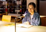 Eine internationale Studierende sitzt in der Bibliothek (WHZ/Helge Gerischer)