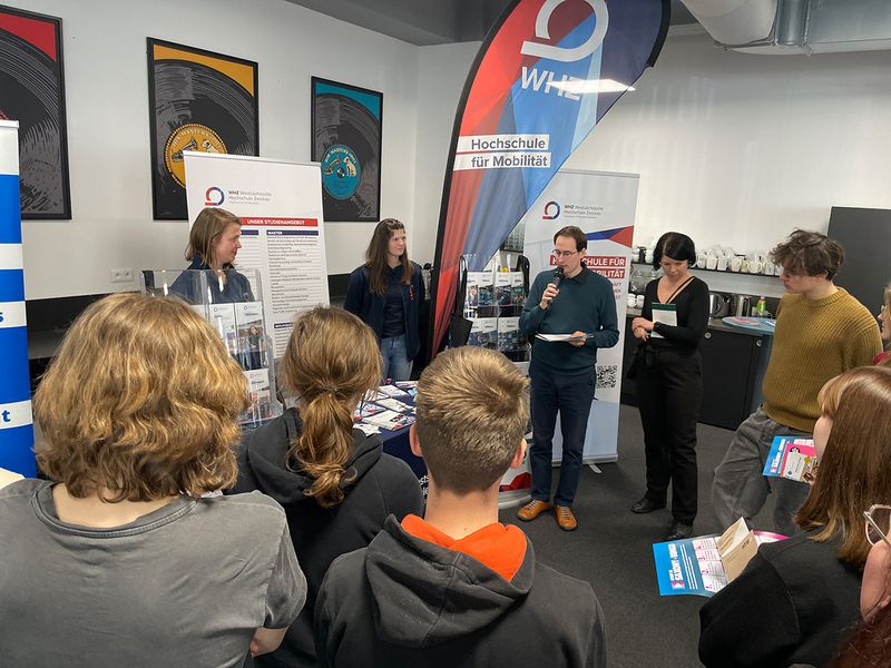 Besucher stehen an einem Messestand der Westsächsischen Hochschule Zwickau. 
