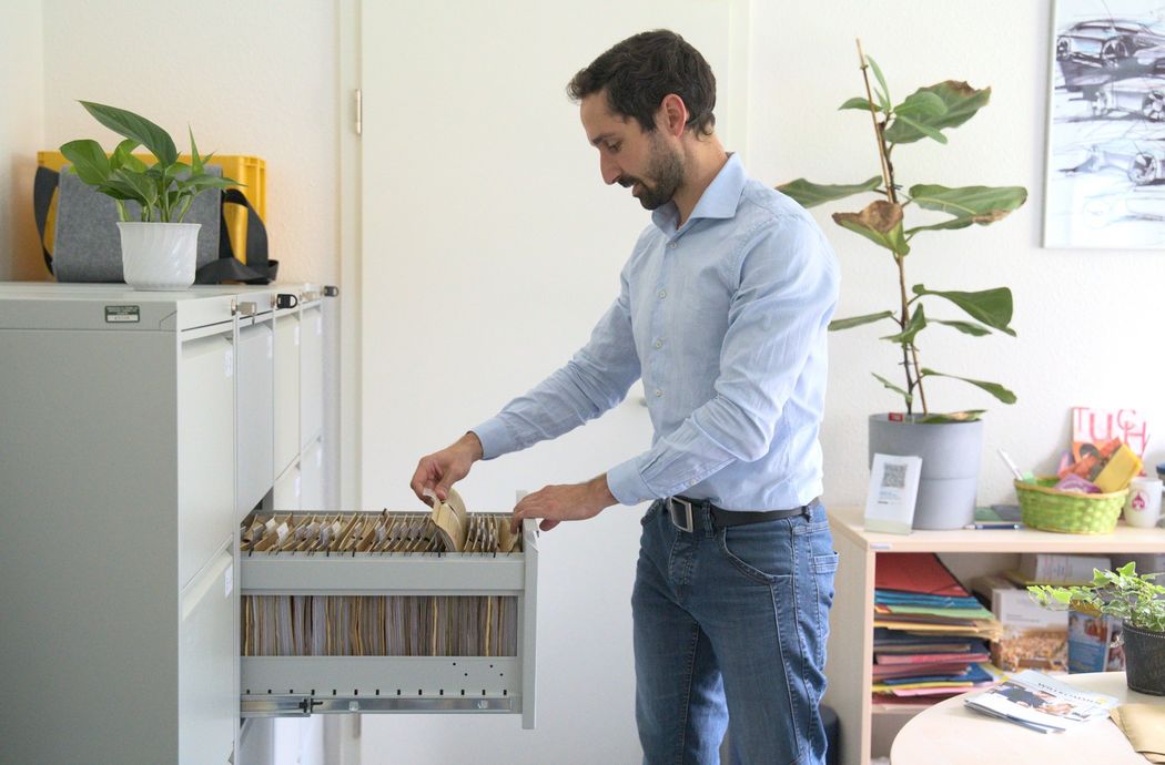 Foto: Ein Mitarbeiter im Dezernat Personalangelegneheiten der WHZ sucht in einem Aktenschrank nach Dokumenten (Quelle: Charlott Wieden)