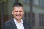 Foto: Portrait eines Mannes, der in die Kamera lächelt.