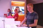 Foto: Drei Studierende stehen an Ausstellungsstücken zum Thema "Wissenschaft zum anfassen" und lächeln in die Kamera.
