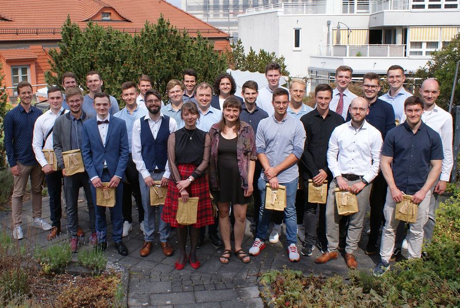 Auf einer Dachterasse stehen 26 junge Menschen.