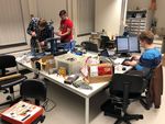 Foto: Drei Studierende um einen Arbeitstisch entwickeln eine Beatmungsmaschine aus dem 3D Drucker.
