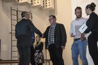 Foto: Vier Absolventen erhalten eine Gratulation und bekommen ihre Urkunden überreicht.