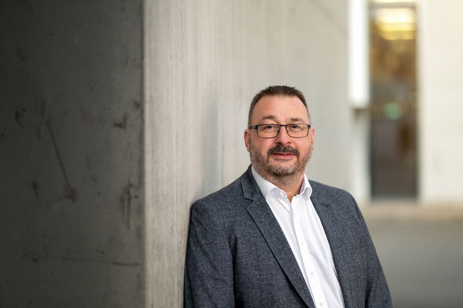Portrait eines Mannes im Anzug der Brille trägt