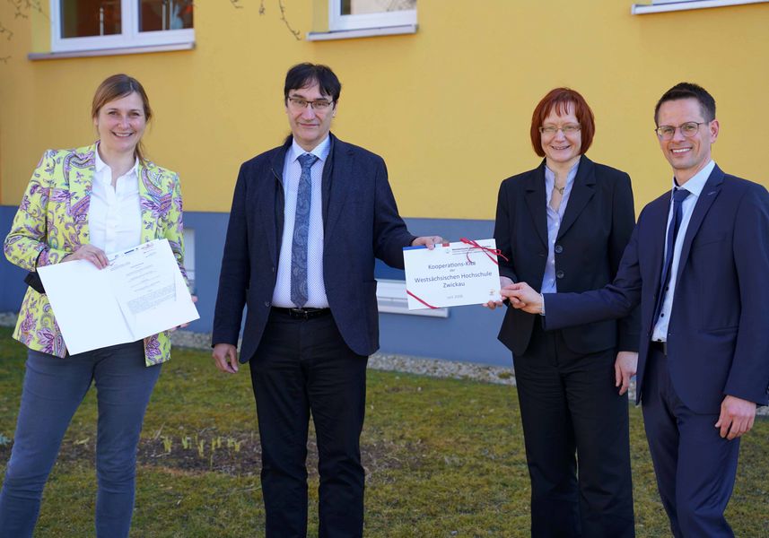 Die Vertragspartner sitzen an Tischen und unterzeichnen Vertragsuntwerlagen.