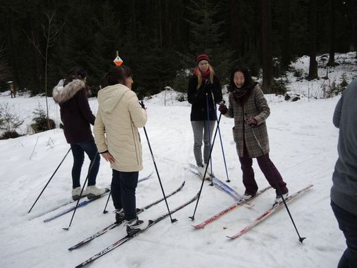 Foto: 4 Personen mit Langlaufski stehen in einer Gruppe zusammen.