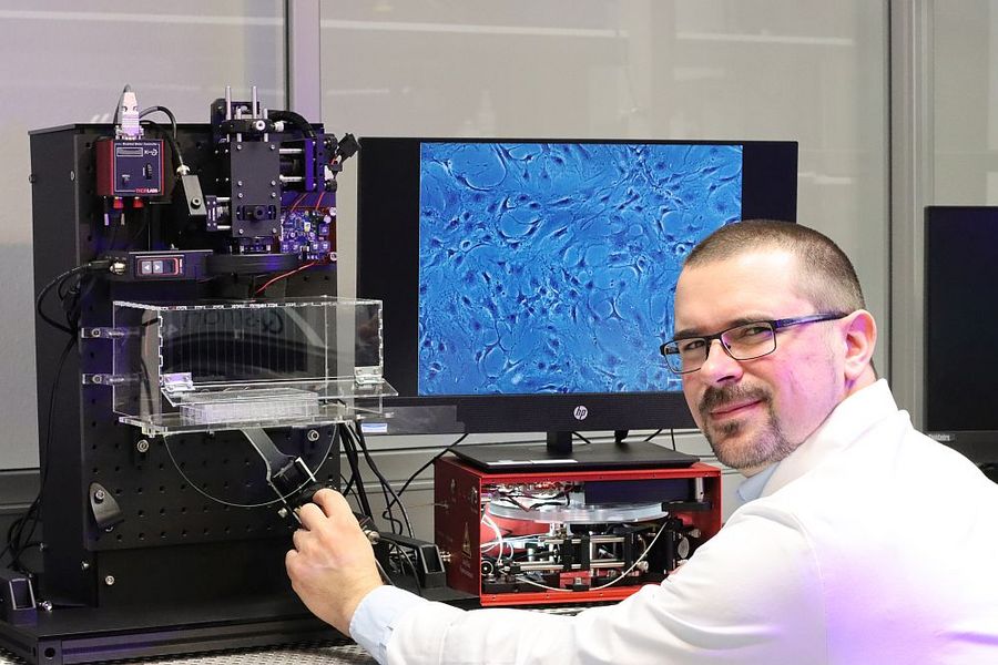 Foto: Ein Mann sitzt vor einem leistungsstarken Weißlichtlaser. 