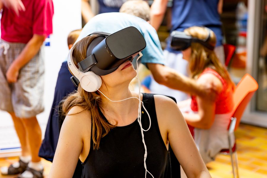 Eine junge Frau mit VR-Brille und Kopfhörern 