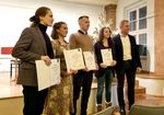 Die Preisträgerinnen und Preisträger stehen auf der Bühne und Präsentieren ihre Urkunden