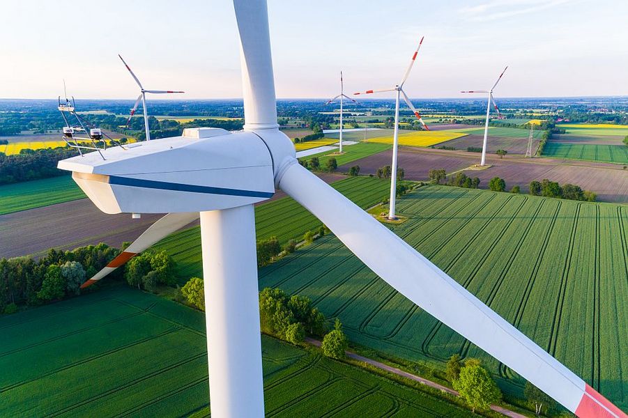 Foto: Mehrere Windräder stehen in einer Landschaft. 