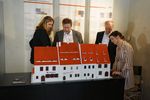 zwei Frauen und zwei Männer betrachten das Tastmodell eines Hauses