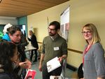Foto: Zwei Mitarbeiter am Messestand zur Integrationsmesse beraten zwei Interessenten.