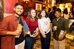 3 Studierende halten Geschenke und lächeln in die Kamera