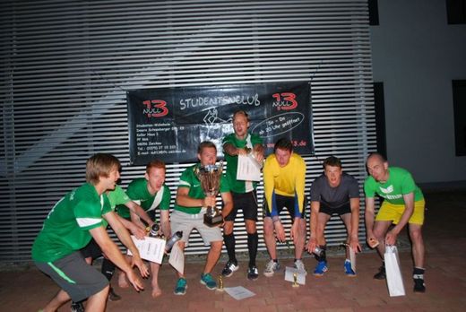 Foto: Gruppenbild von 7 Hochschulsportteilnehmern mit Pokal und Urkunden.
