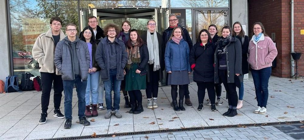 Gruppe von Menschen steht vor dem Glaseingang des August Horch Museums. 