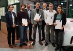 Gruppenbild mit Studierenden und Professoren. Personen lächeln und halten Urkunden in der Hand.