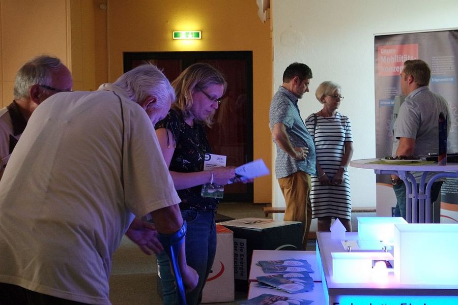 Foto: Interessierte stehen an einem Informationsstand.