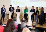 eine Gruppe von Menschen auf der Bühne zur Begürßung vor einem Auditorium