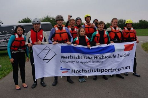 Foto: Gruppenbild der Kitesurfcamp Teilnehmer mit dem Banner des Hochschulsportzentrum.
