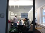Foto: Blick in einen Konferenzraum. Studierende sitzen an einem Konferenztisch und führen ein Meeting.