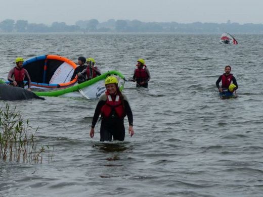 Foto: Teilnehmer des Kitesurfcamp kommen aus dem Wasser heraus.